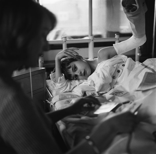 Volunteer UVV (Union of Volunteers) with child in hospital, 1964