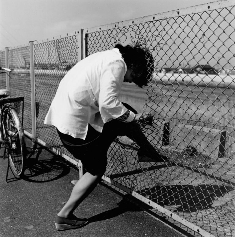 Woman passing through wire netting