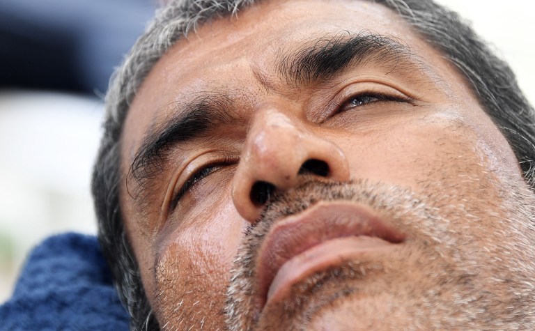 Very ill Rohingya refugee Salim Kwawning lies on a table in the Lombrum centre abandoned by Australia